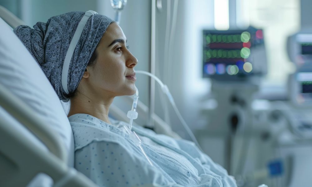 A woman in a hospital bed with PowerPort looking thoughtful in a healthcare setting.