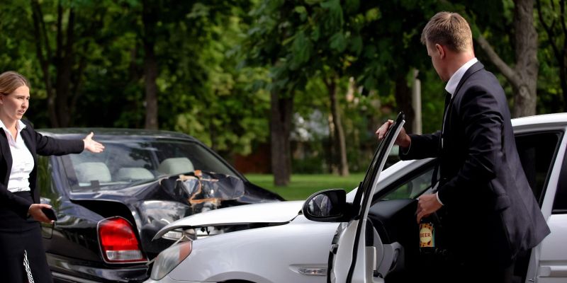 a man and a woman standing in front of their cars after a crash