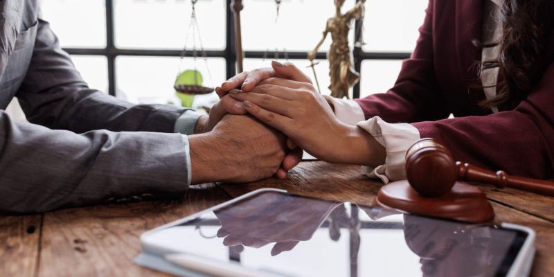 Couple holding hands at a table, receiving support for