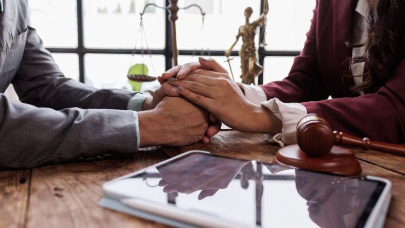 Couple holding hands at a table, receiving support for