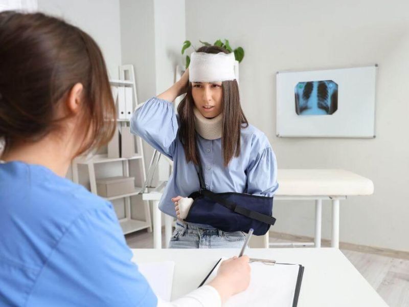Woman with head cast at desk, reflecting
