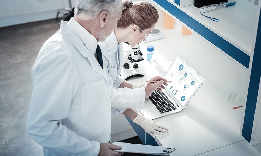 Scientists analyzing data on PFAS chemicals in laboratory setting.