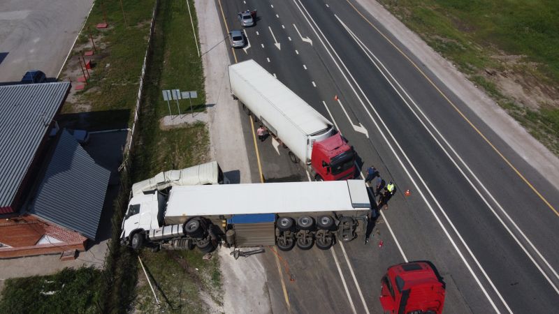 Aerial view of an overturned truck on I-81 in Virginia, surrounded by emergency response vehicles and debris.
