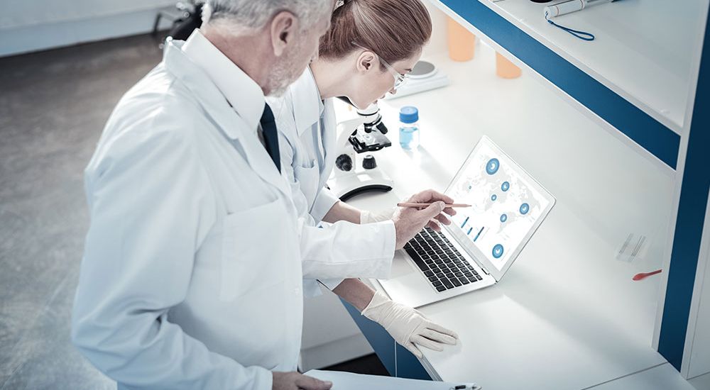 Scientists analyzing data on PFAS chemicals in laboratory setting.