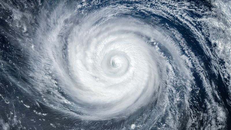 Satellite view of a massive hurricane swirling over the ocean, showcasing the eye and spiral cloud bands.