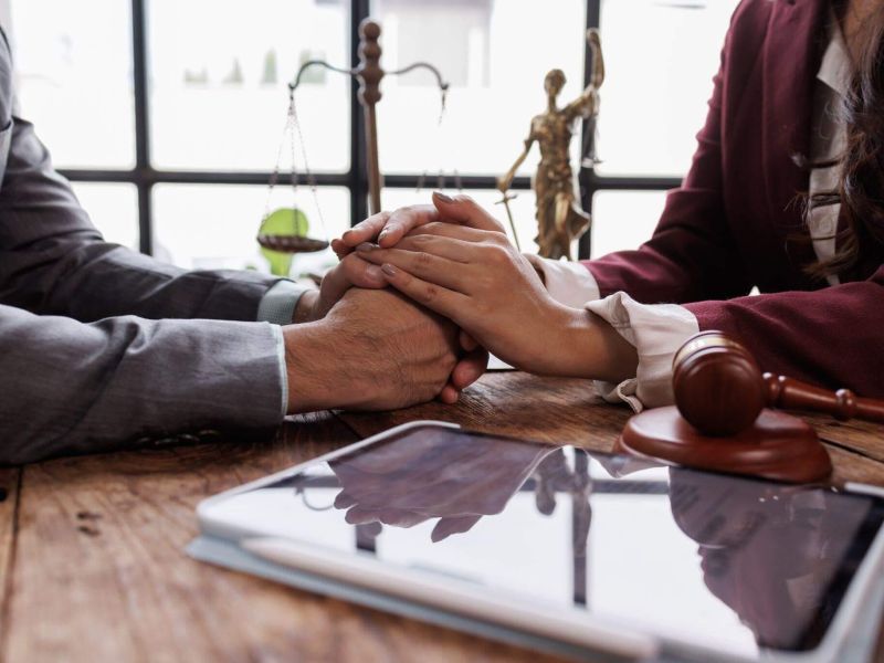 Couple holding hands at a table, receiving support for