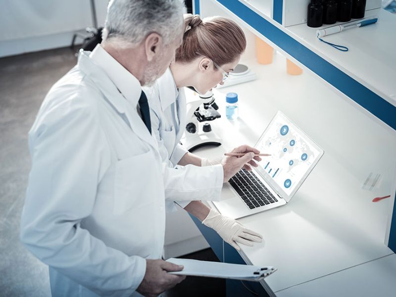 Scientists analyzing data on PFAS chemicals in laboratory setting.