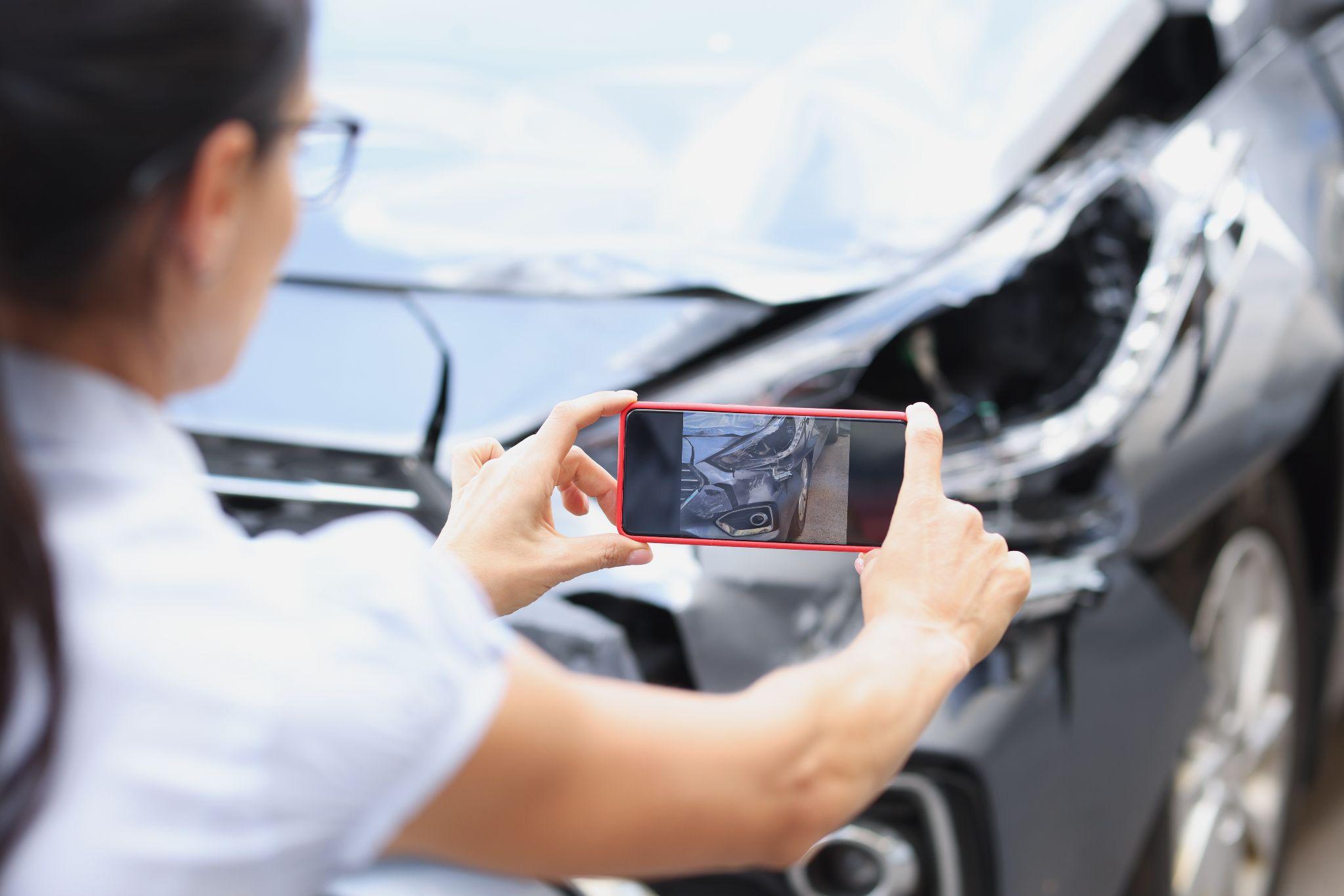 a woman taking a picture of a car accident