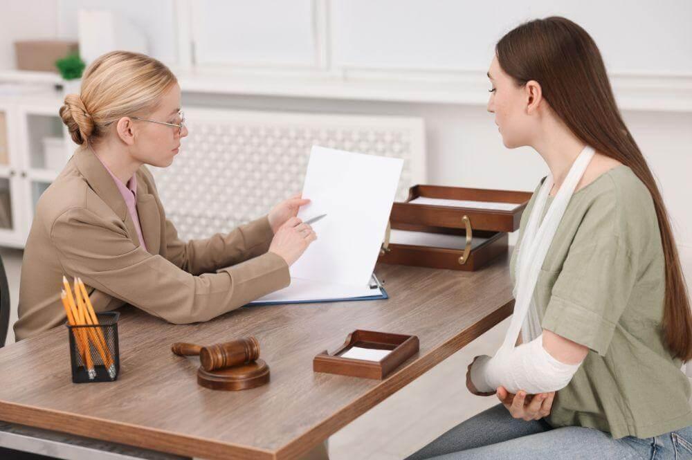 Two women review legal documents at a table,