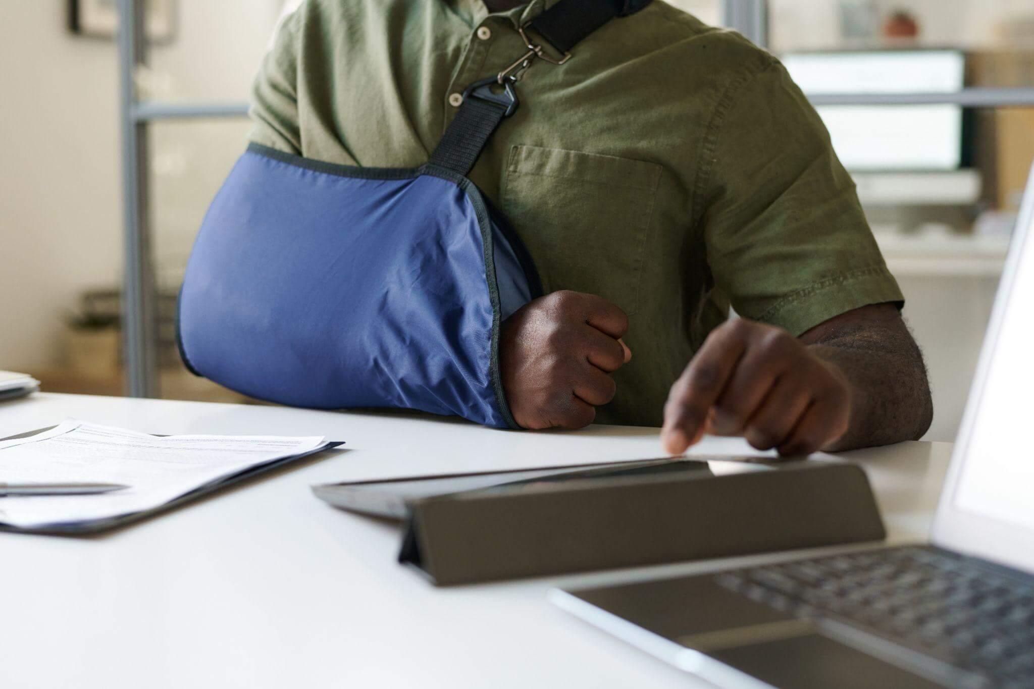 Man at desk reviewing insurance documents on a laptop