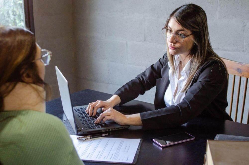 Woman on laptop researching personal injury settlement