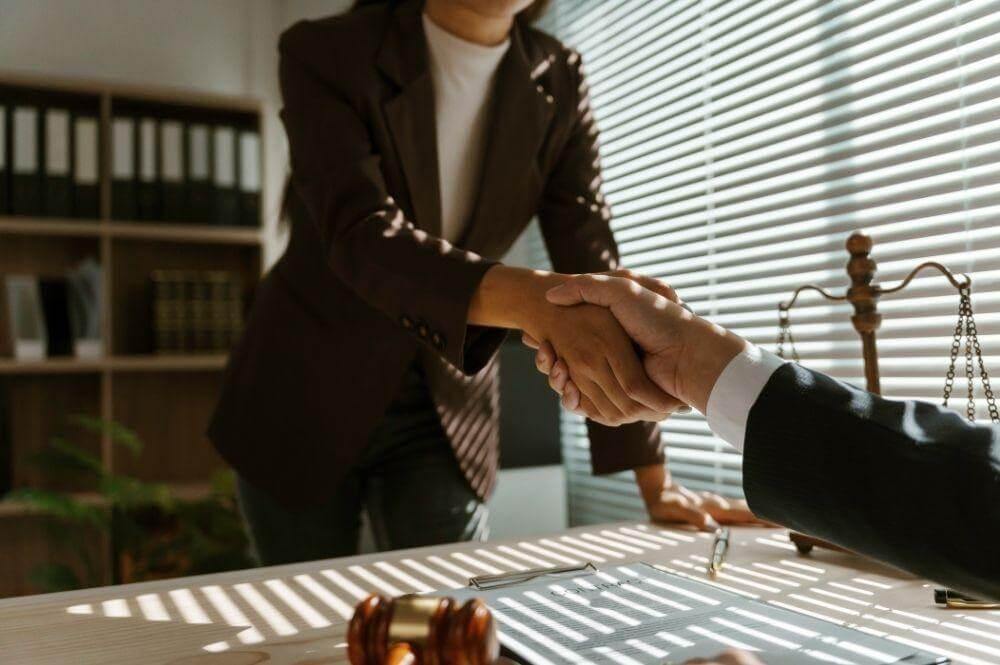 Legal professionals shaking hands, implying an agreement or