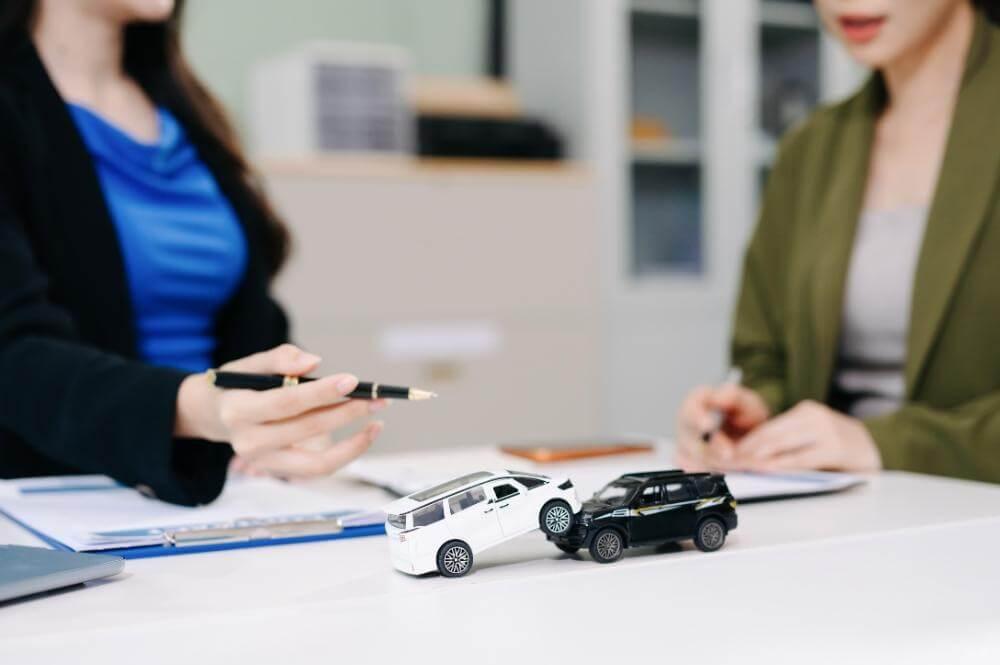 Two women discuss car accident specifics with a